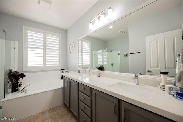 bathroom featuring a shower stall, a bath, double vanity, and a sink