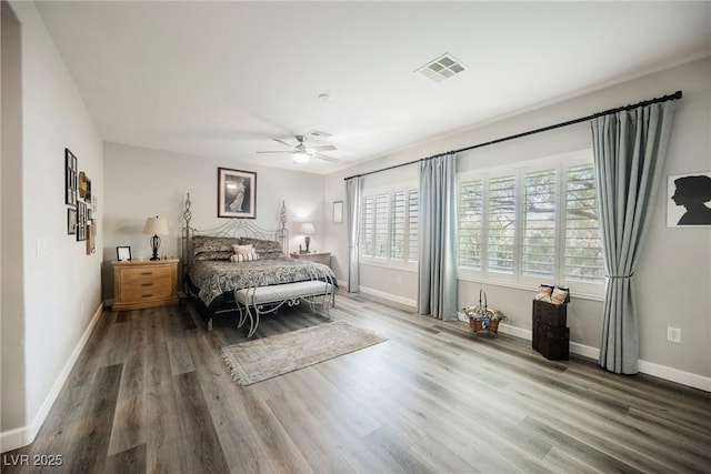 bedroom featuring ceiling fan, wood finished floors, visible vents, and baseboards