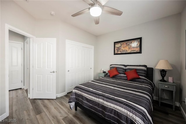 bedroom with a closet, a ceiling fan, baseboards, and wood finished floors