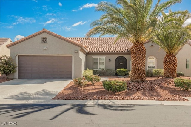 mediterranean / spanish house with stucco siding, a tiled roof, driveway, and a garage