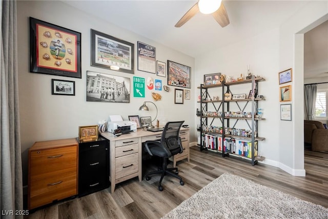 home office featuring baseboards, a ceiling fan, and wood finished floors