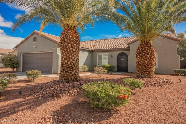 mediterranean / spanish-style home with concrete driveway, a tiled roof, a garage, and stucco siding