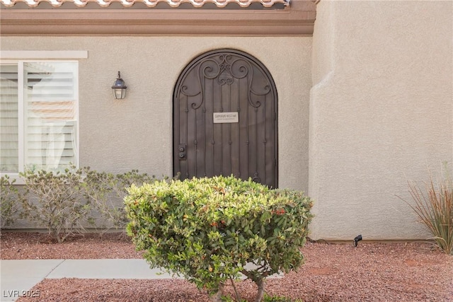 property entrance with a tiled roof and stucco siding