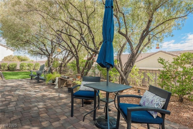 view of patio with outdoor dining space and fence