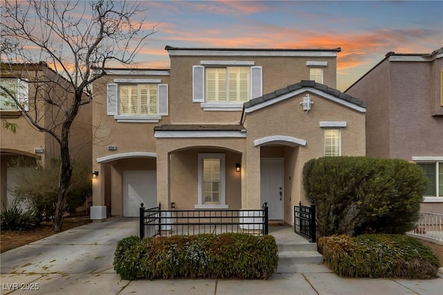 view of front of property with a garage, a porch, driveway, and stucco siding