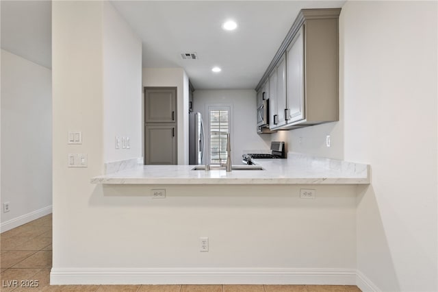 kitchen featuring baseboards, visible vents, appliances with stainless steel finishes, and a sink