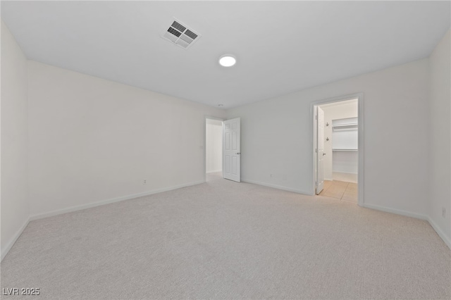 unfurnished room featuring visible vents, light colored carpet, and baseboards