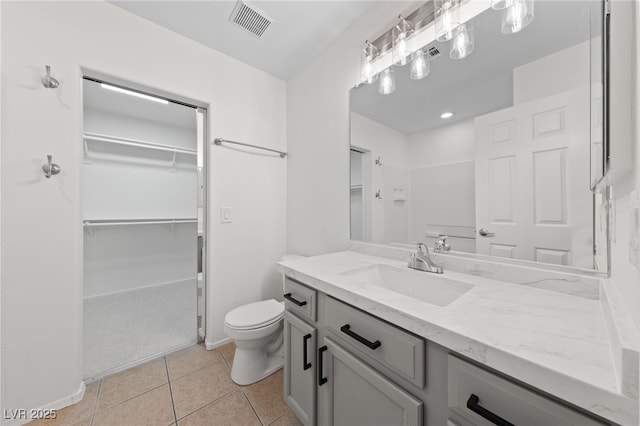 full bath with tile patterned flooring, visible vents, a spacious closet, toilet, and vanity