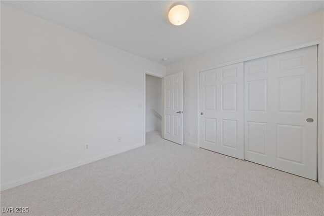 unfurnished bedroom featuring baseboards, carpet floors, and a closet