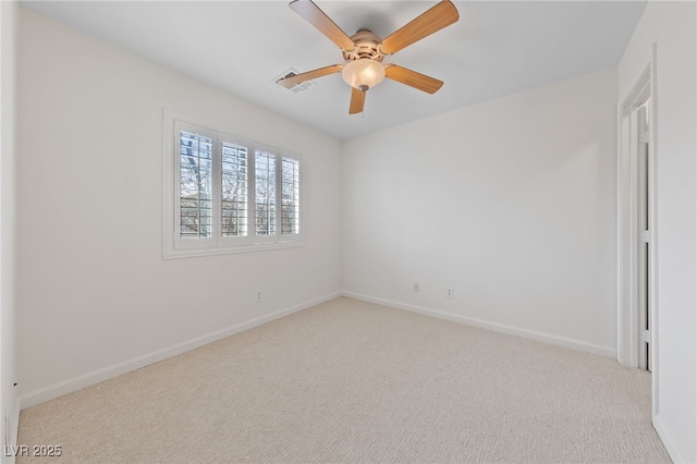 spare room with baseboards, carpet floors, visible vents, and ceiling fan