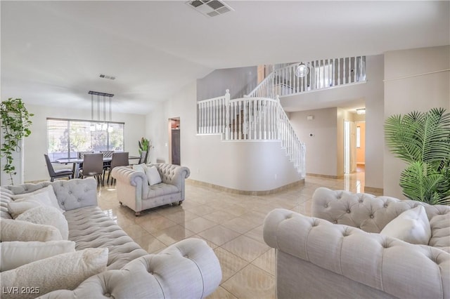 living room featuring stairway, light tile patterned floors, baseboards, visible vents, and lofted ceiling