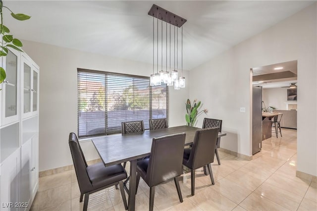 dining space with light tile patterned floors, a notable chandelier, and baseboards