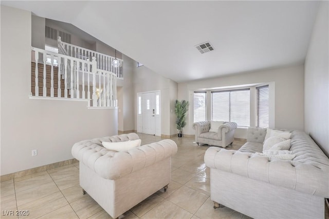 tiled living area with visible vents, baseboards, and vaulted ceiling