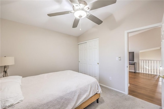 carpeted bedroom featuring a closet, a ceiling fan, baseboards, and vaulted ceiling