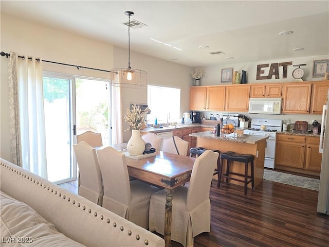 dining area featuring visible vents, plenty of natural light, and dark wood-type flooring