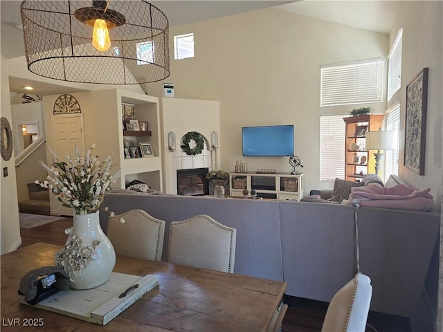 living area featuring dark wood-type flooring, stairway, and high vaulted ceiling