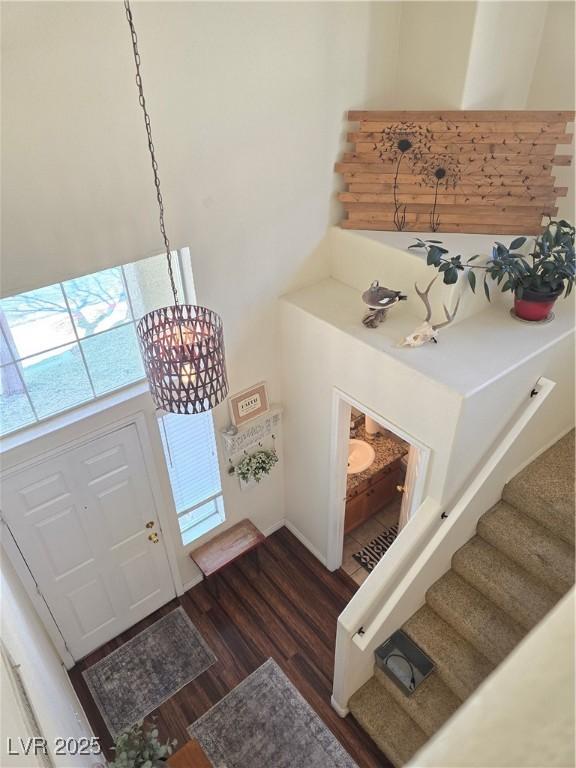 entryway featuring stairs, a notable chandelier, and dark wood-style floors