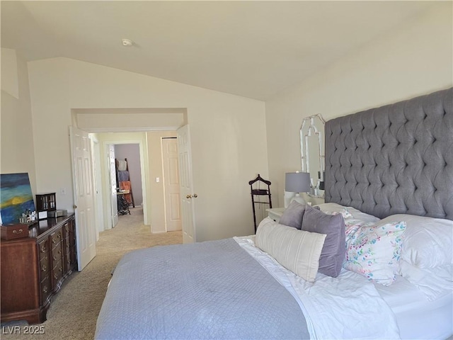 bedroom featuring lofted ceiling and light colored carpet