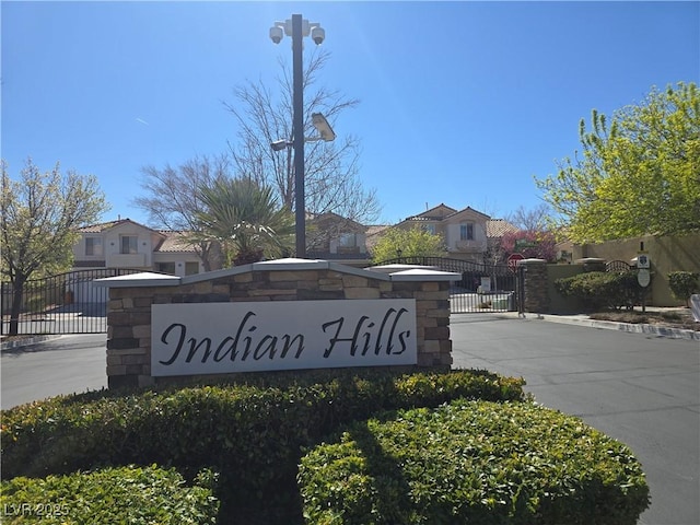 community / neighborhood sign with a gate, a residential view, and fence