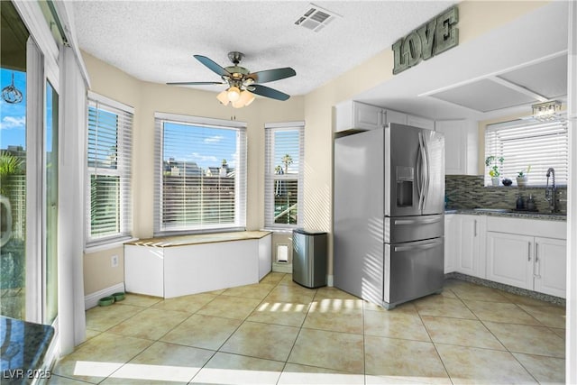 3258 Del Marino St, Las Vegas, NV 89121 - kitchen featuring stainless steel fridge with ice dispenser, a ceiling fan, light tile patterned flooring, tasteful backsplash, and a textured ceiling