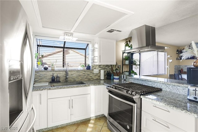 3258 Del Marino St, Las Vegas, NV 89121 - kitchen with appliances with stainless steel finishes, light tile patterned floors, white cabinets, decorative backsplash, and light stone countertops