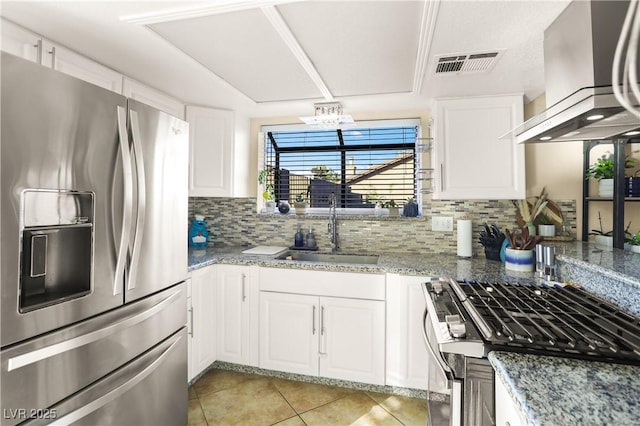 3258 Del Marino St, Las Vegas, NV 89121 - kitchen featuring stainless steel appliances, wall chimney range hood, light tile patterned flooring, tasteful backsplash, and white cabinetry