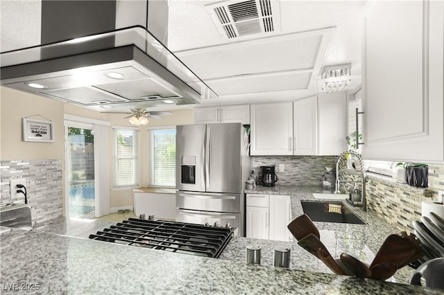 3258 Del Marino St, Las Vegas, NV 89121 - kitchen featuring stainless steel fridge with ice dispenser, wall chimney exhaust hood, backsplash, and white cabinetry