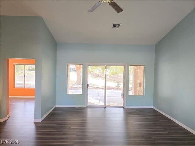 spare room featuring baseboards, visible vents, dark wood finished floors, lofted ceiling, and ceiling fan