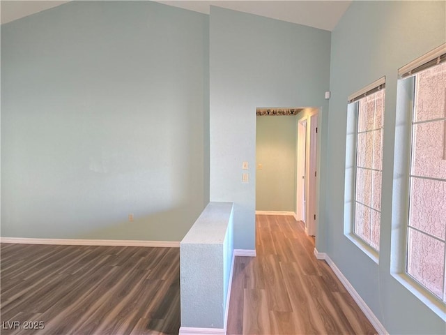 hallway featuring wood finished floors and baseboards