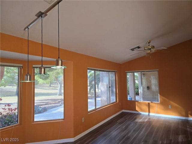 unfurnished dining area featuring visible vents, baseboards, vaulted ceiling, a wealth of natural light, and dark wood-style floors