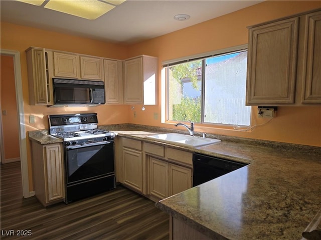 kitchen featuring dark countertops, dark wood-style flooring, black appliances, and a sink