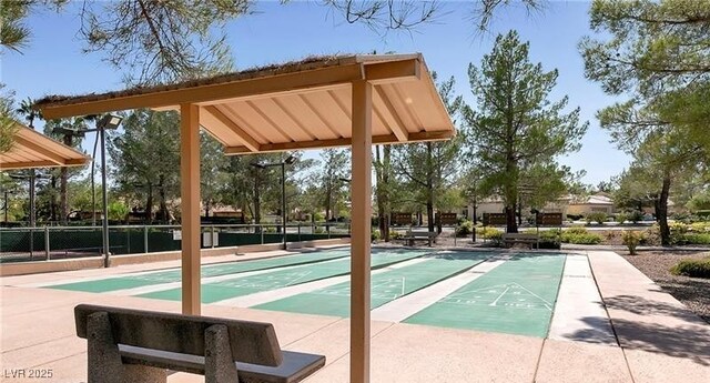 view of home's community featuring shuffleboard and fence