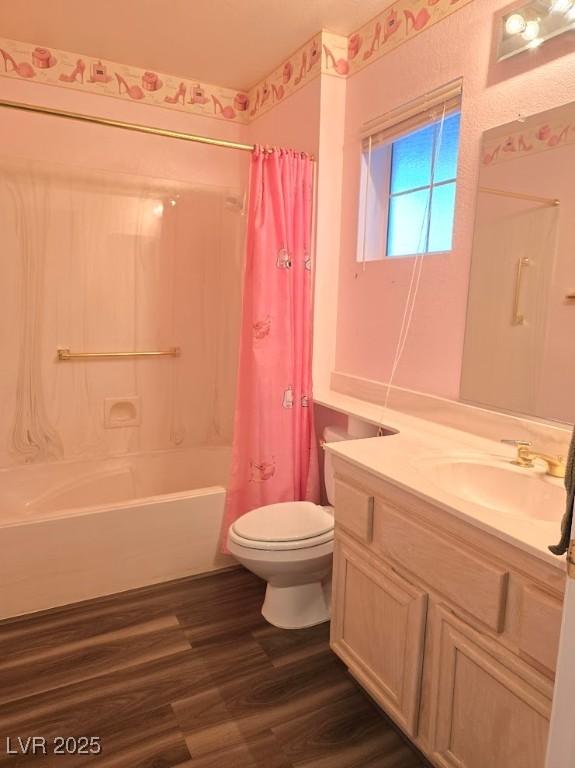 bathroom featuring shower / bath combination with curtain, toilet, vanity, and wood finished floors