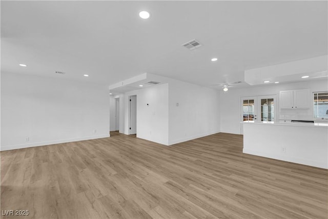 unfurnished living room with light wood finished floors, visible vents, baseboards, ceiling fan, and recessed lighting