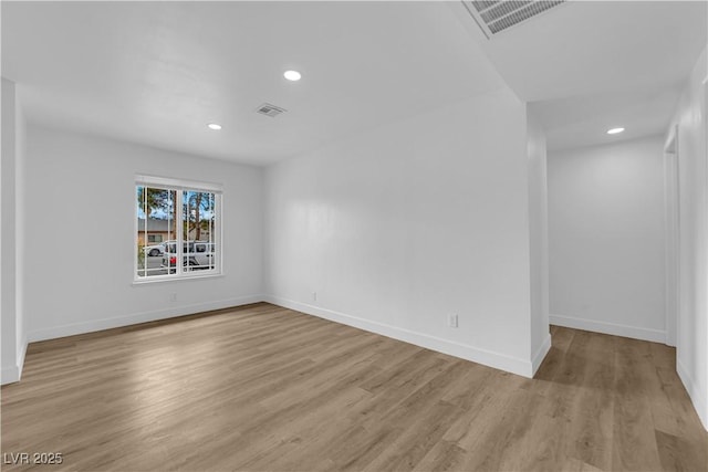 empty room featuring visible vents, recessed lighting, baseboards, and wood finished floors