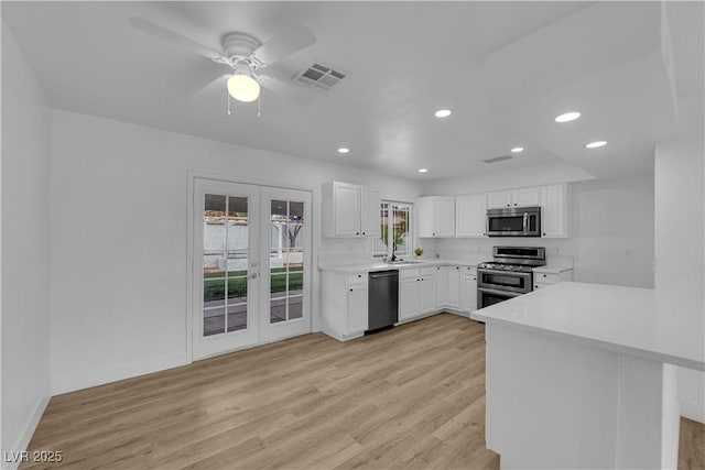 kitchen featuring visible vents, a sink, french doors, appliances with stainless steel finishes, and light wood finished floors