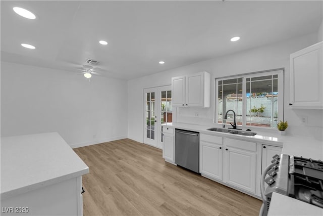 kitchen featuring appliances with stainless steel finishes, light countertops, ceiling fan, and a sink