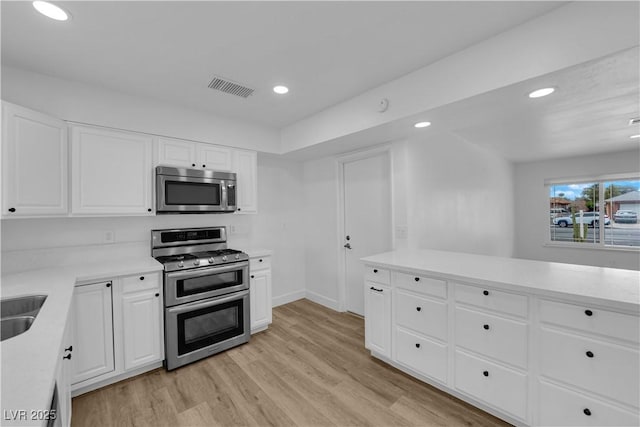 kitchen with visible vents, recessed lighting, stainless steel appliances, light countertops, and light wood-type flooring