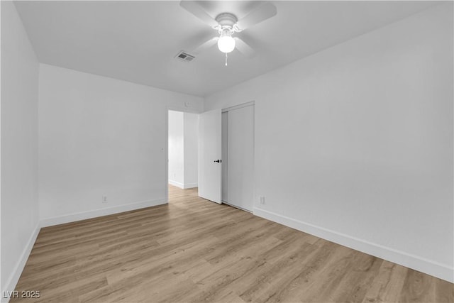 spare room featuring a ceiling fan, wood finished floors, visible vents, and baseboards