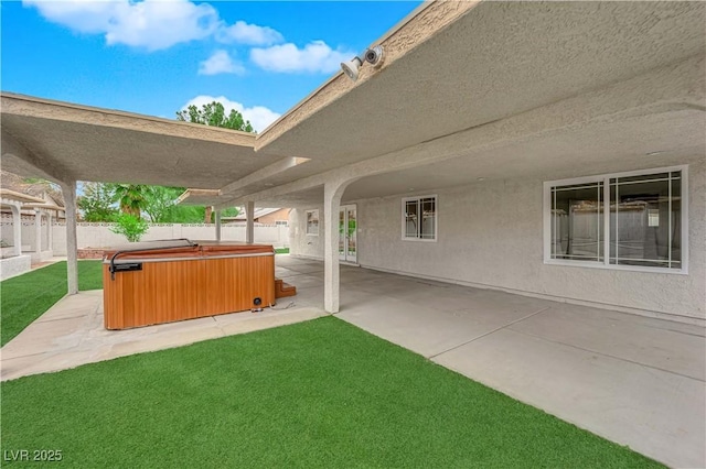 view of patio featuring a hot tub and a fenced backyard