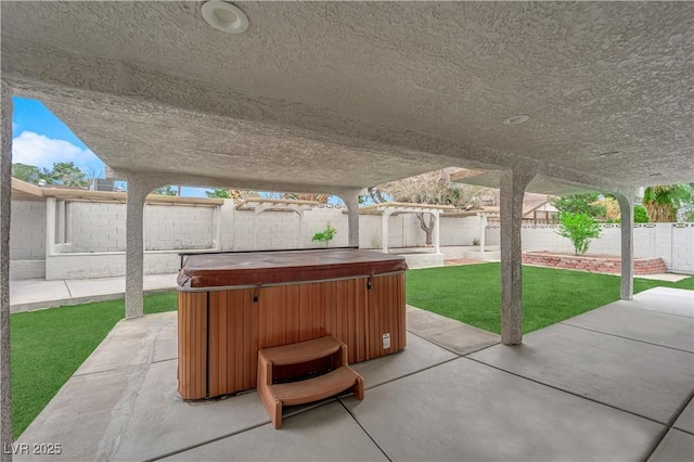 view of patio featuring a hot tub and a fenced backyard