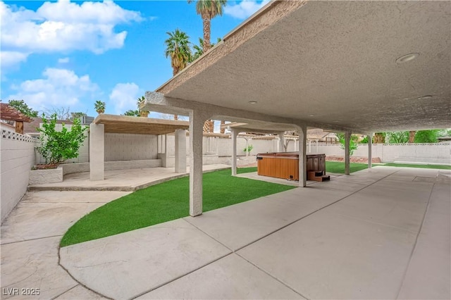 view of patio / terrace featuring a fenced backyard and a hot tub