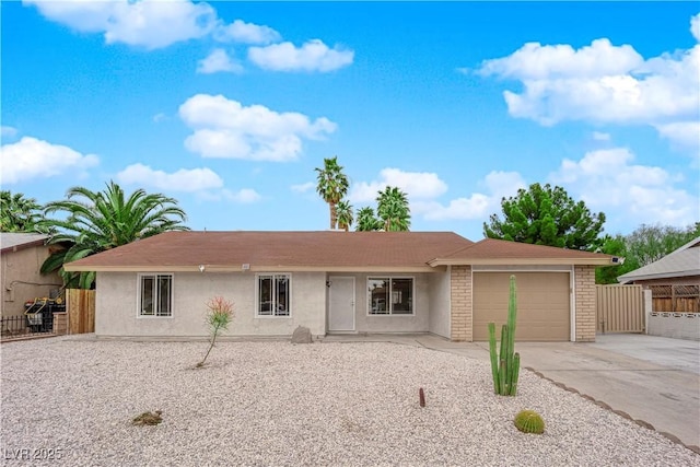 ranch-style home featuring stucco siding, driveway, an attached garage, and fence