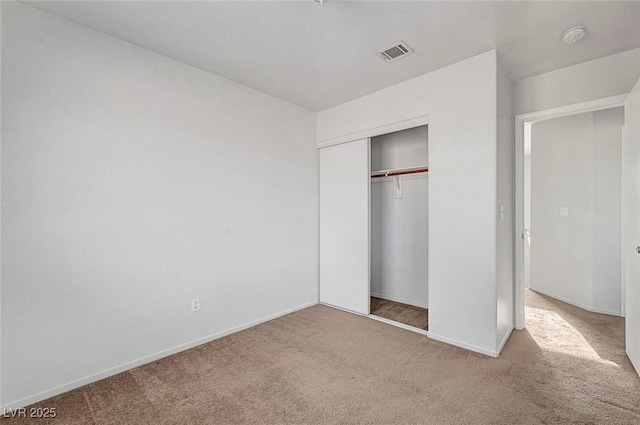 unfurnished bedroom with carpet flooring, baseboards, visible vents, and a closet