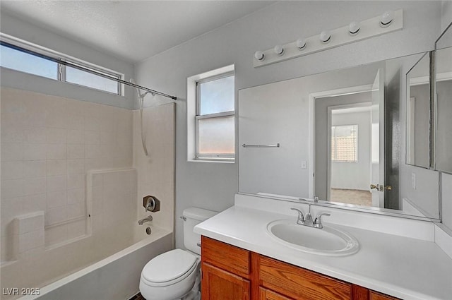 bathroom with shower / washtub combination, a healthy amount of sunlight, toilet, and vanity