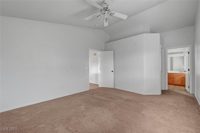 unfurnished bedroom with a sink, connected bathroom, light carpet, and vaulted ceiling