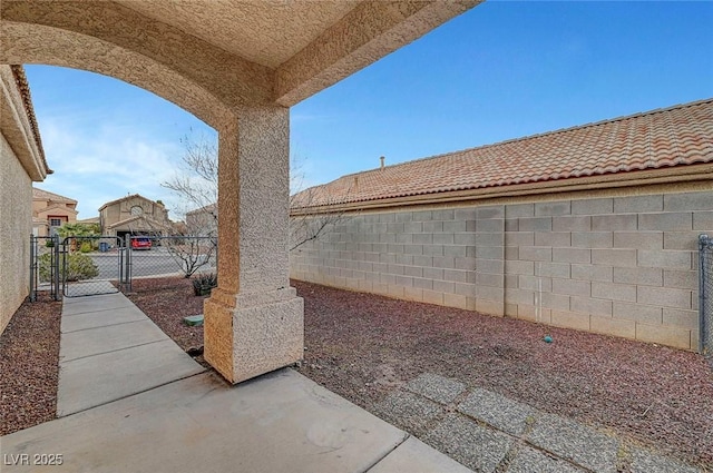 view of yard with a patio, a fenced backyard, and a gate