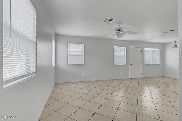 unfurnished room with visible vents, baseboards, light tile patterned flooring, and a ceiling fan