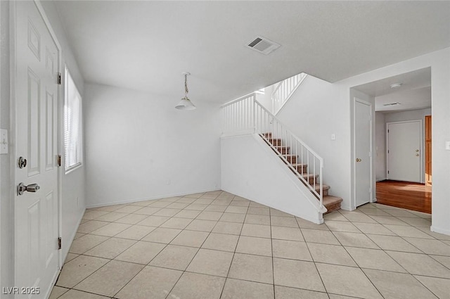 interior space with light tile patterned floors, visible vents, and stairs