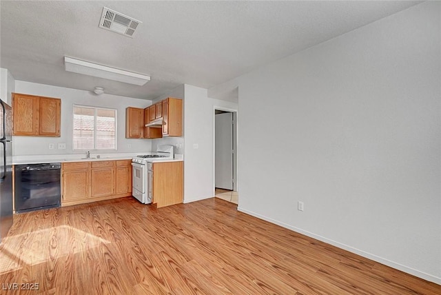 kitchen featuring visible vents, light wood finished floors, white range with gas stovetop, light countertops, and dishwasher